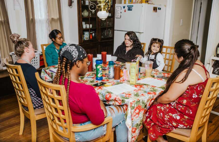 group of women sitting around the table eating