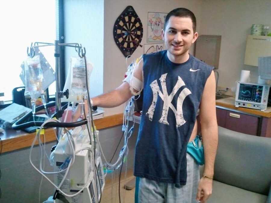man waits in the hospital holding an iv pole for a heart for transplant