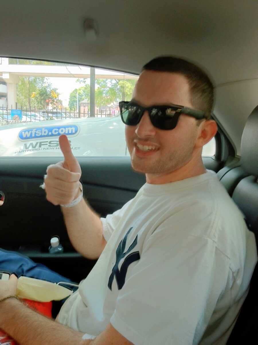 man who received a heart transplant sitting in the car leaving the hospital after surgery