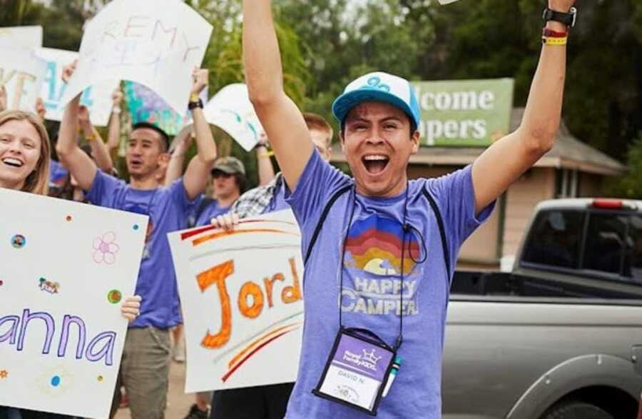 Summer camp volunteer having a great time with foster kids.