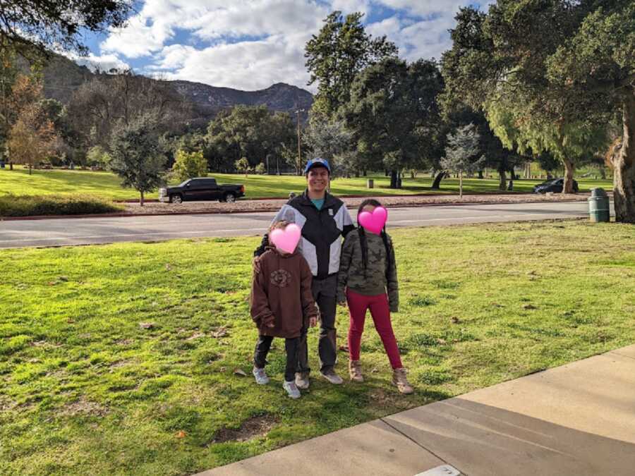 Foster dad walks in park with foster daughters.