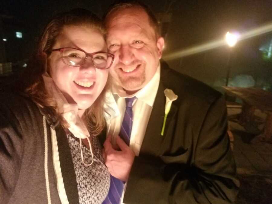 Couple takes selfie wearing formal attire, smiling with their heads pressed together.