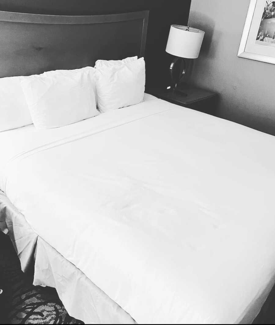 Black and white image of neat hotel bed