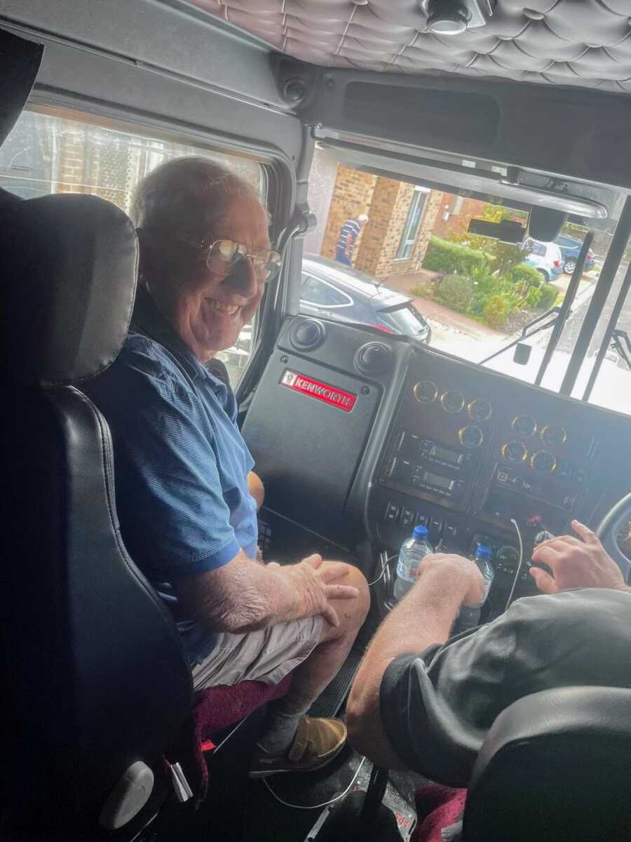 elderly man smiles widely while sitting passenger in a big rig