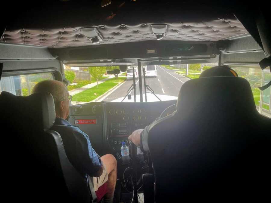 elderly man sits passenger as a man drives him in his big rig as an act of kindness