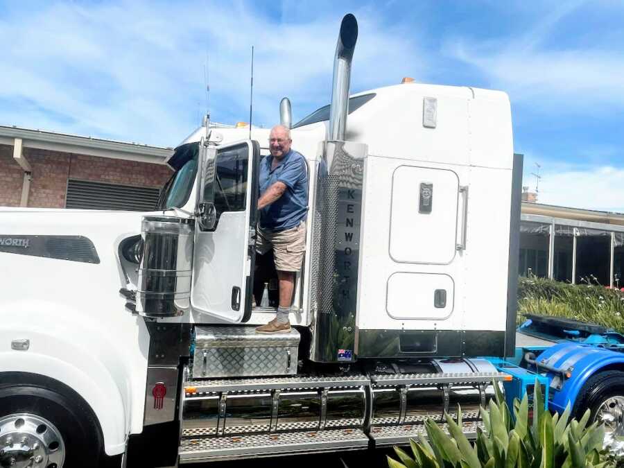 elderly man stands on a big rig after a stranger lets him explore the truck
