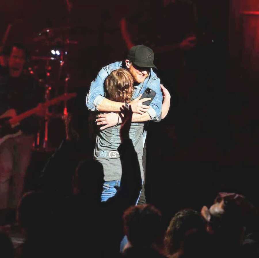 Cole Swindell gives a fan he invited on stage at his show a big hug