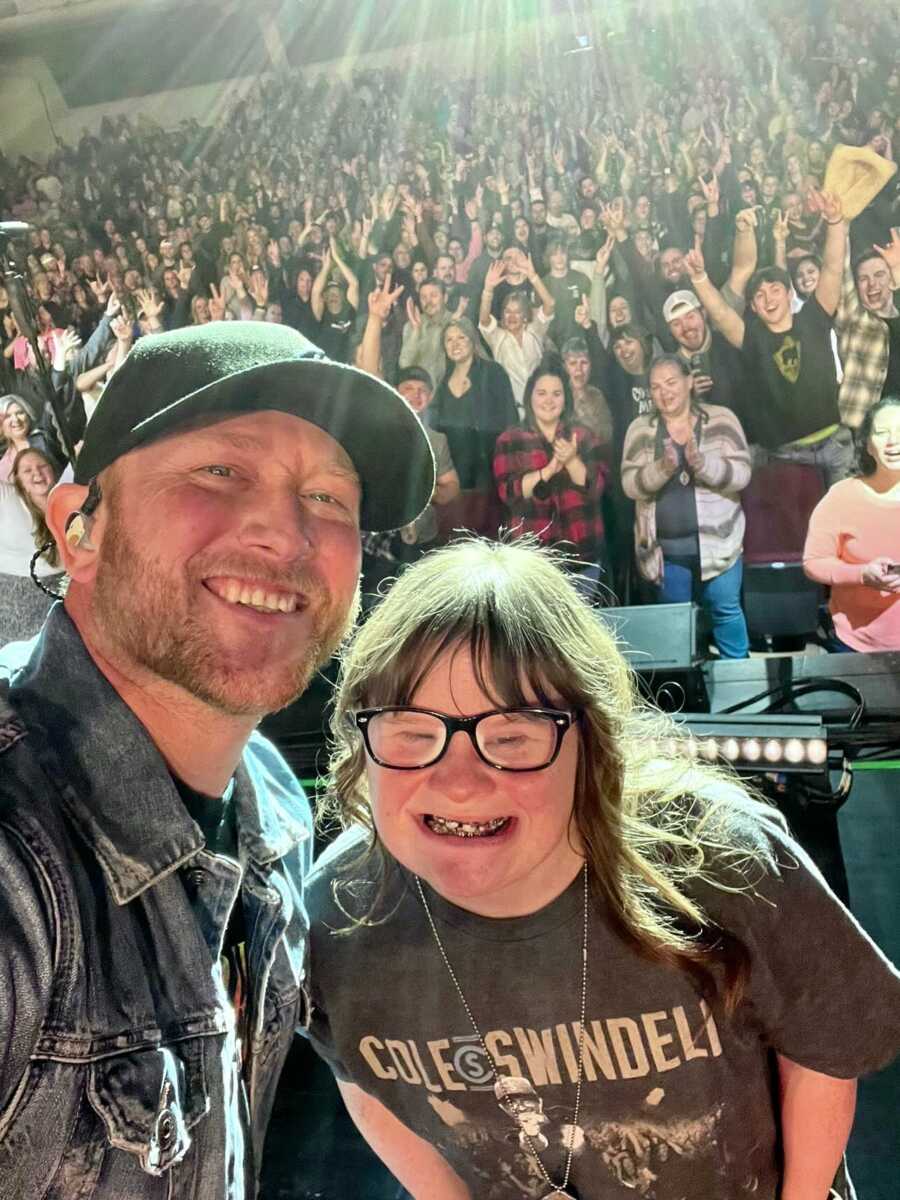 young woman with down syndrome joins Cole Swindell for a selfie