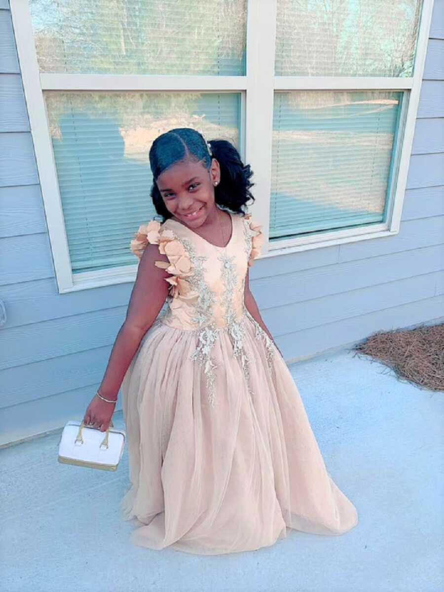 Little girl in gold dress gets ready to go to school dance with older brother.