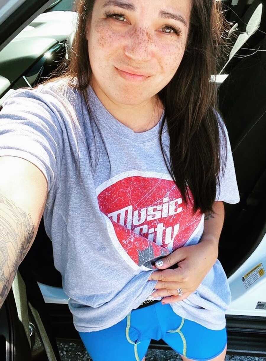 tired mom stands wearing an old shirt with a pair of her husbands old underwear