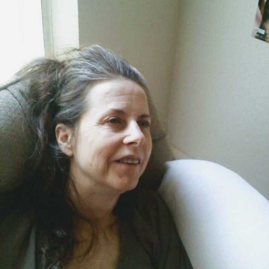 Mom with Alzheimer's disease gazing from gray chair
