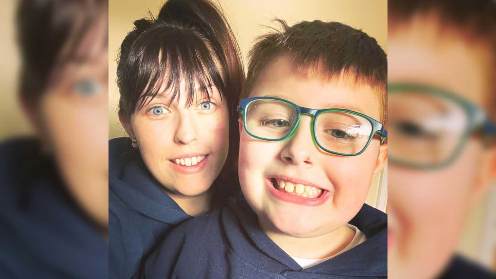 A mom and her autistic son, who is wearing green glasses