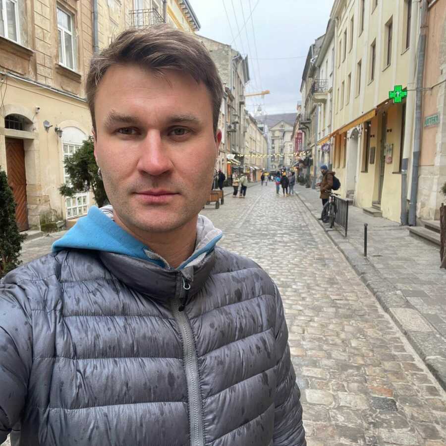 Ukrainian man stands in cobblestone streets of Lviv.