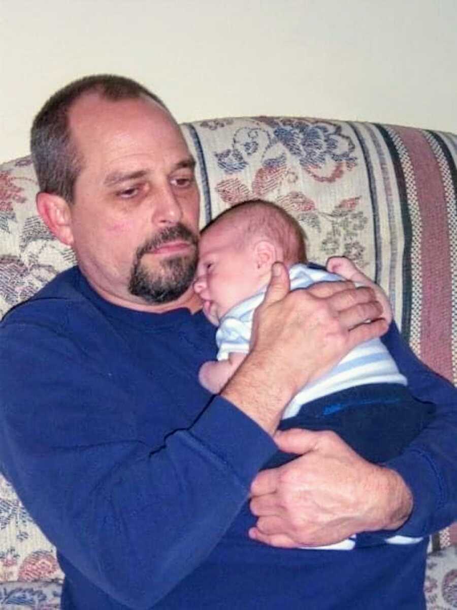 grandpa holds his grandson to his chest