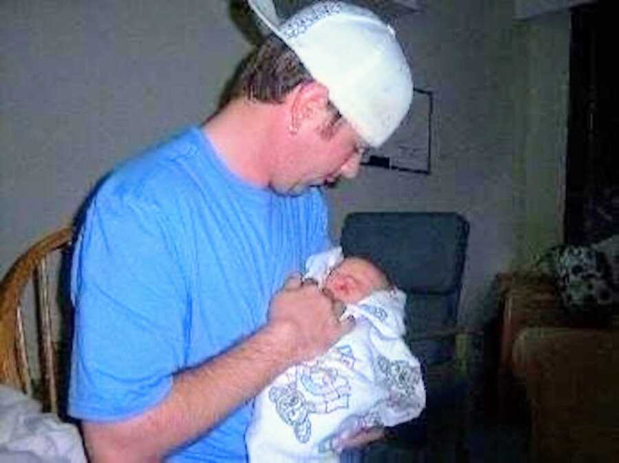 father holds his newborn son in the hospital not long after birth