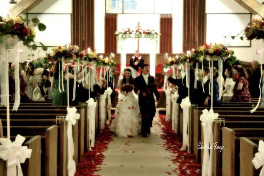 wedding photo of a young couple, they are walking down the aisle at a church