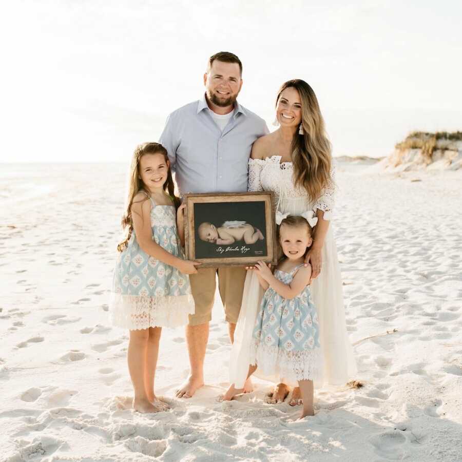 family, mom, dad, two daughters, hold an image of their son/brother who passed from S.I.D.S.