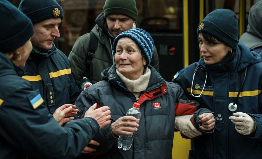 Elderly woman receives assistance as she tries to evacuate.