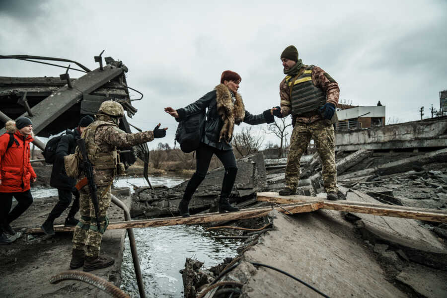 Military helps Ukrainians cross water.