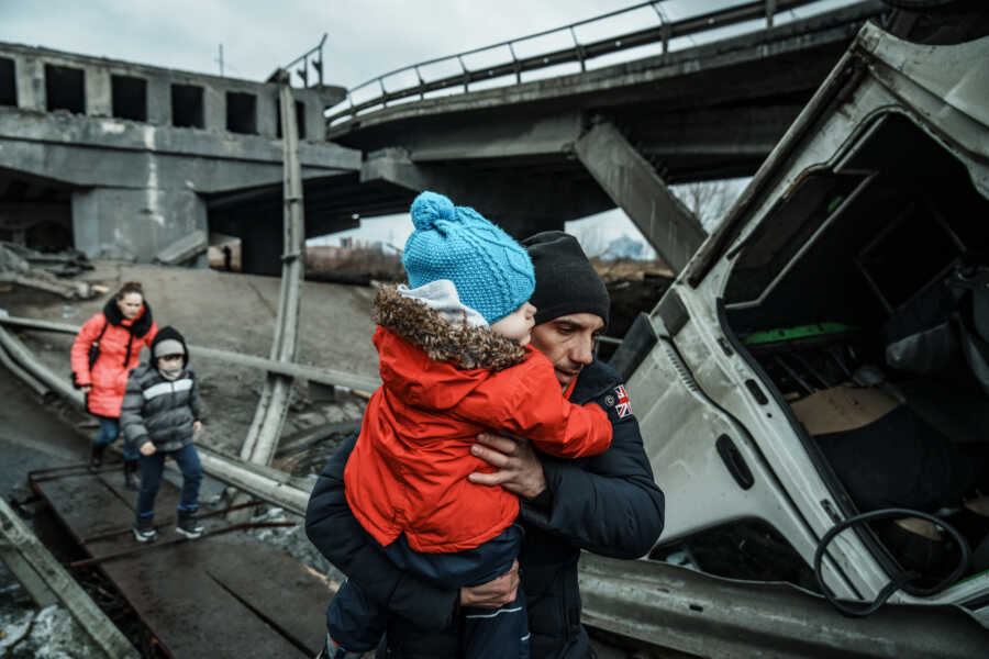 Ukrainian father carries small child.