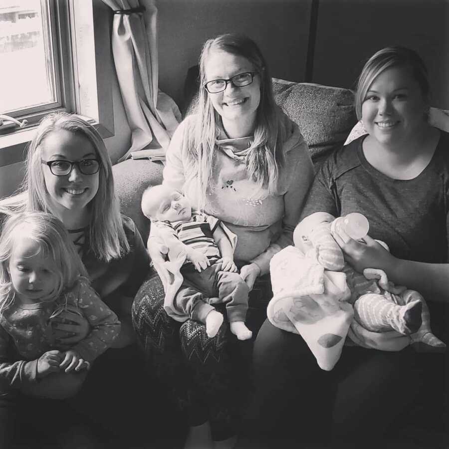 mother sits with her own mom and sibling, each of them is holding a child