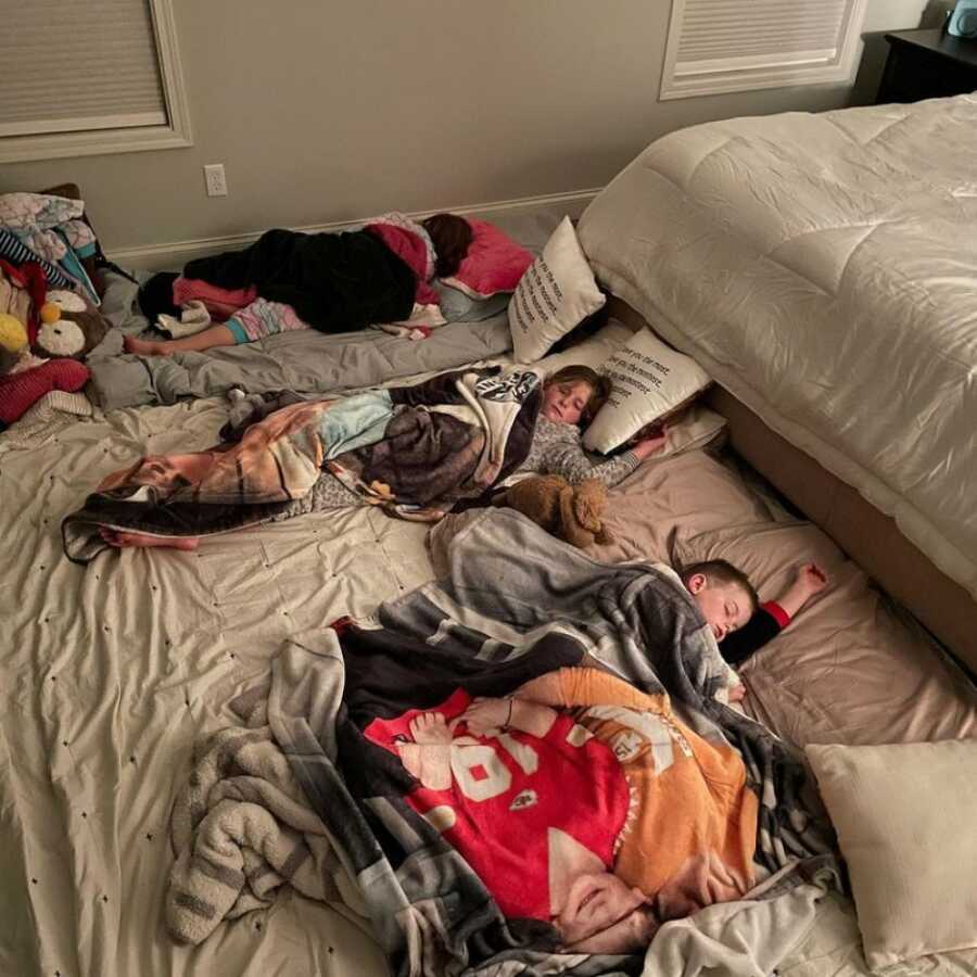 little kids sleeping at the floor of their father's bed after the loss of their mother