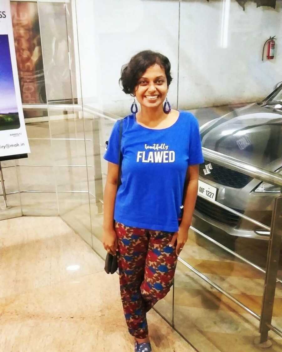 woman smiling in a cool shirt next to a car