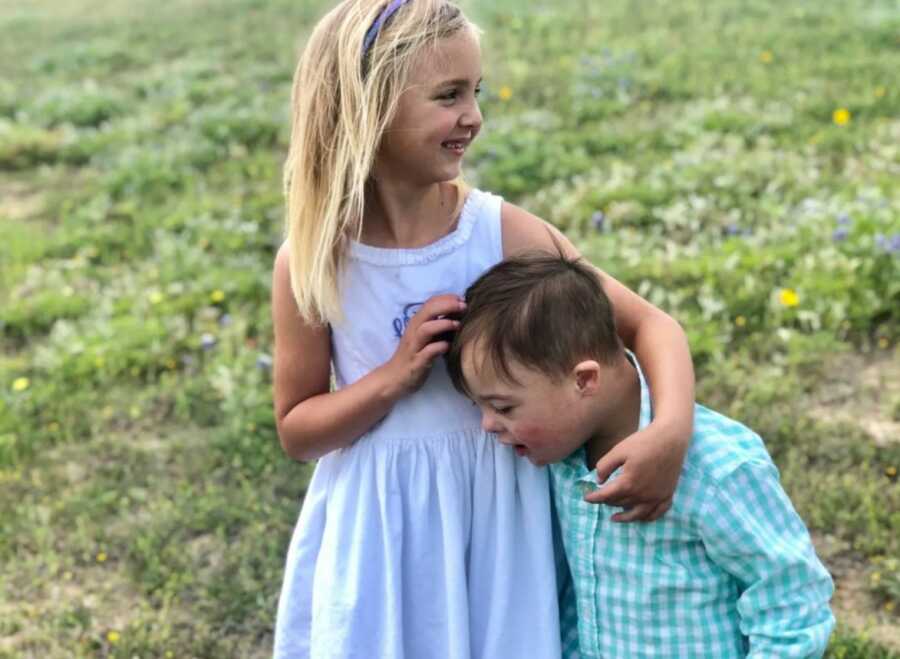 little girl and her brother playing in a field