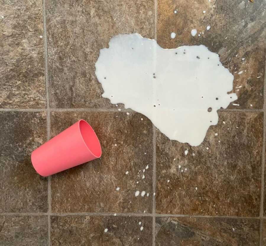 spilled milk on tile floor with pink cup