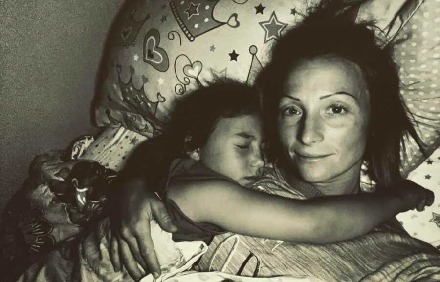 woman holding her daughter while she sleeps