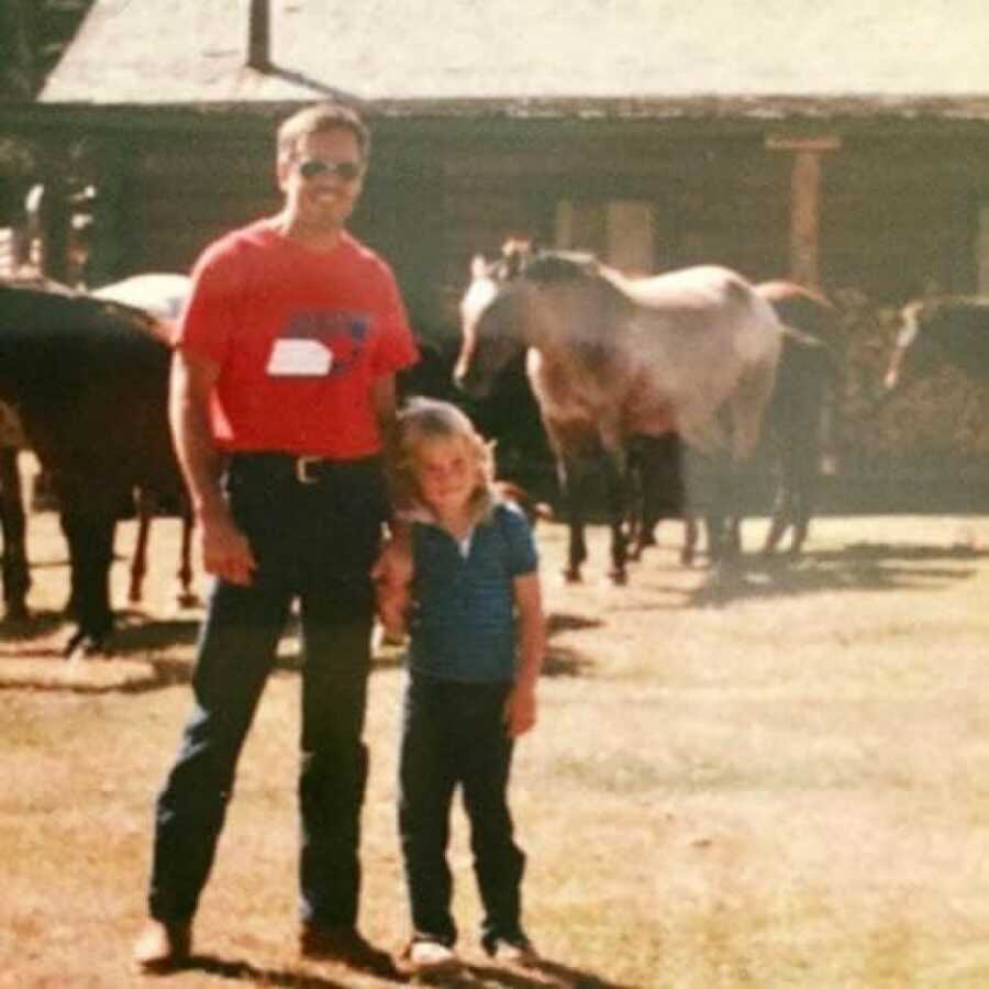 daughter and her father in a stable with horses