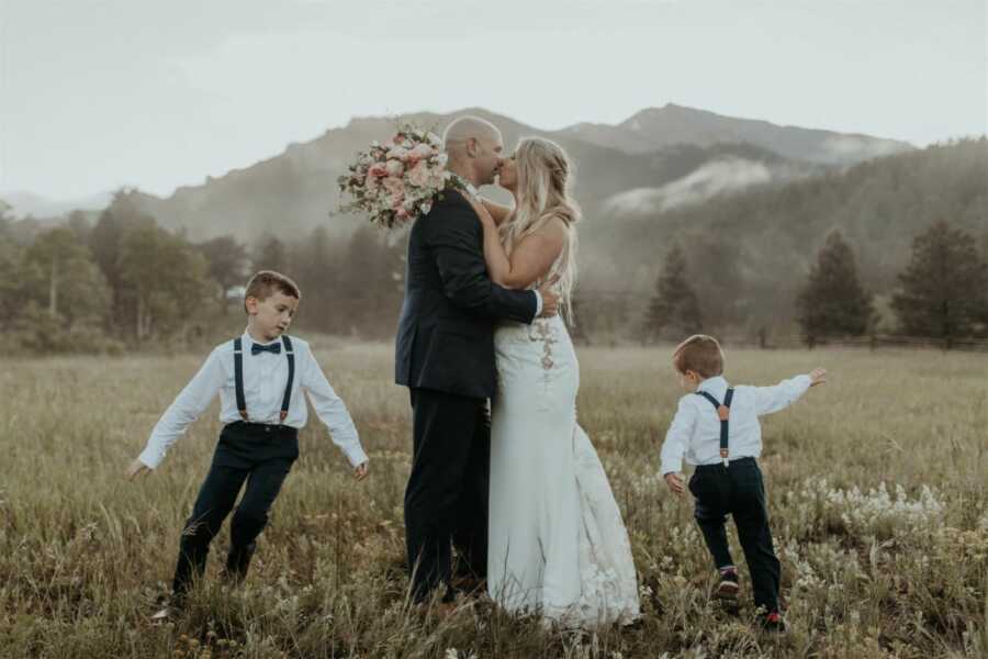 Two sons run around their parents while they kiss on their wedding day in Zion National Park