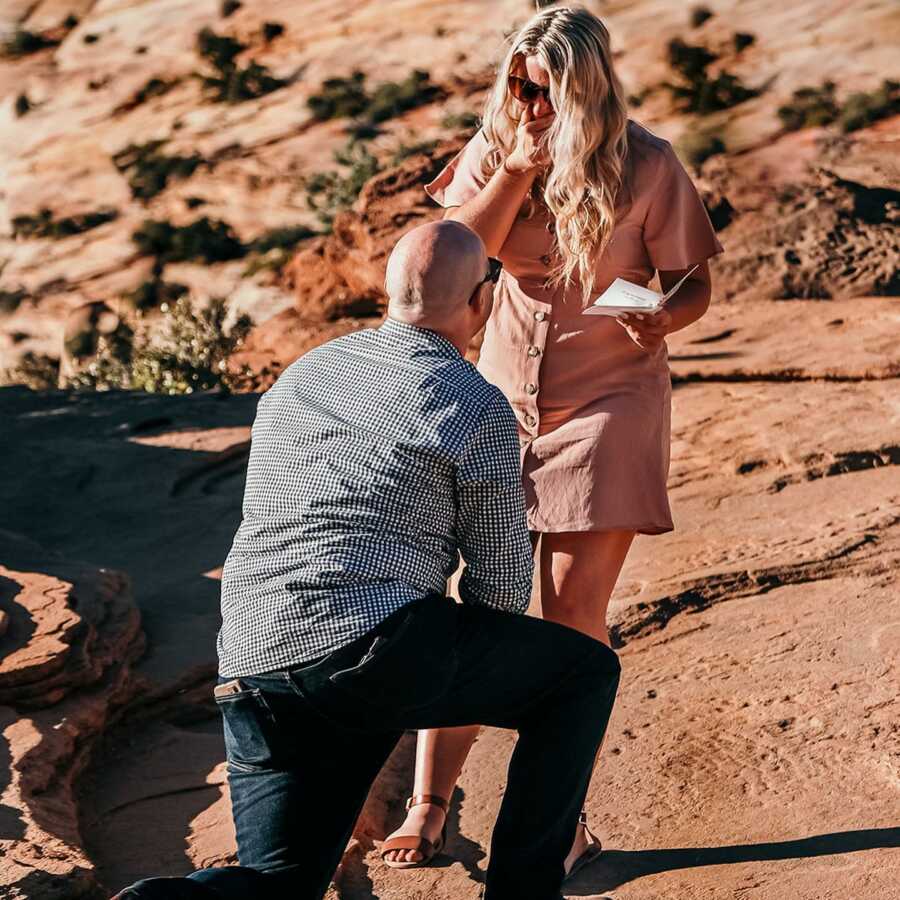 Woman looks shocked while boyfriend proposes to her in Zion National Park