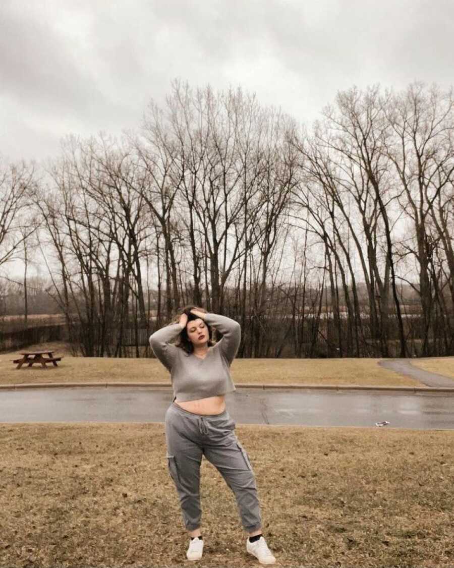 Woman embracing the gray of life takes metaphorical photo in gray tracksuit outside on a gloomy day