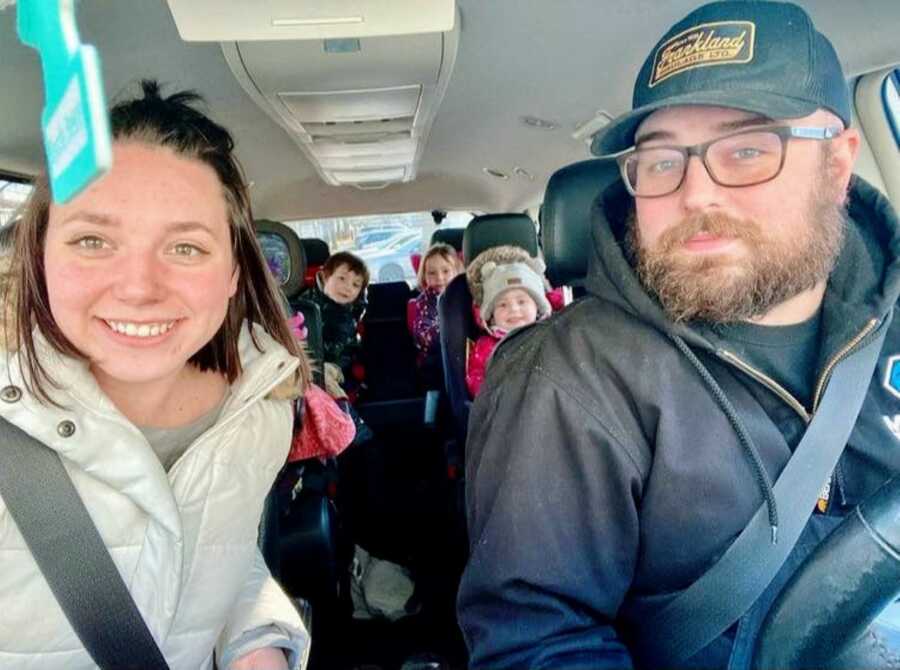 Family of six take a group selfie during a car ride