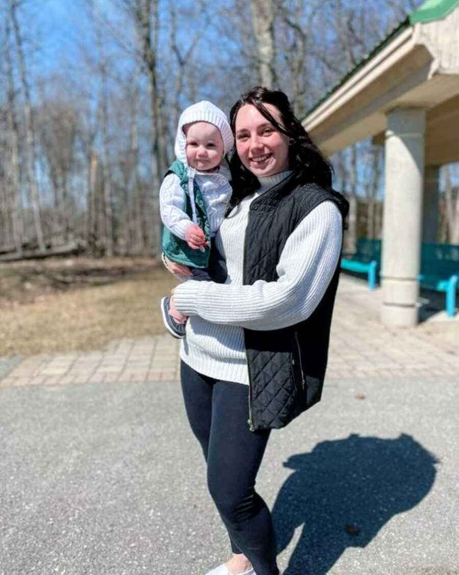 Mom and daughter bundle up in matching white sweaters in the cold