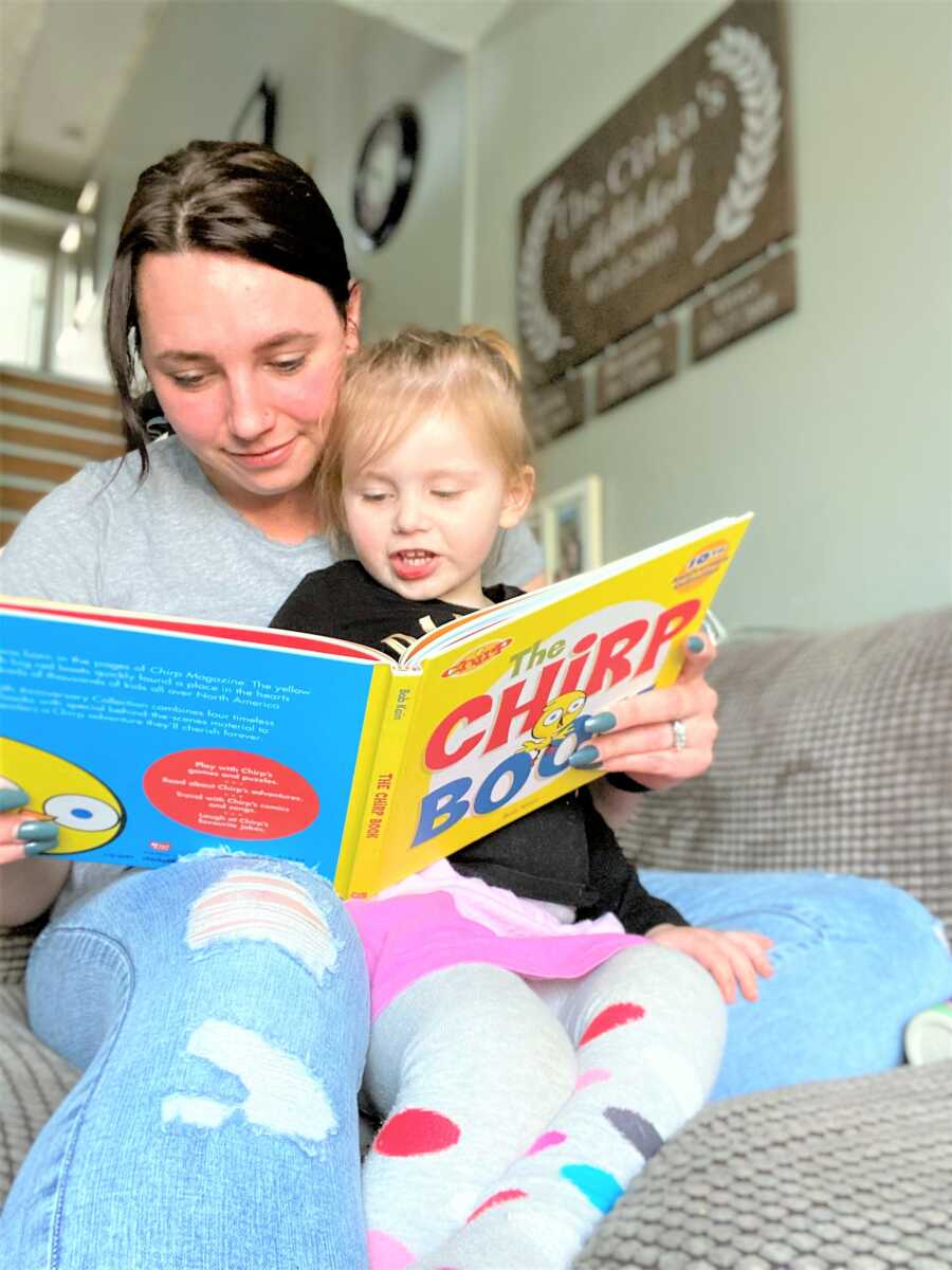 Mom and her toddler daughter reading a kid's book together