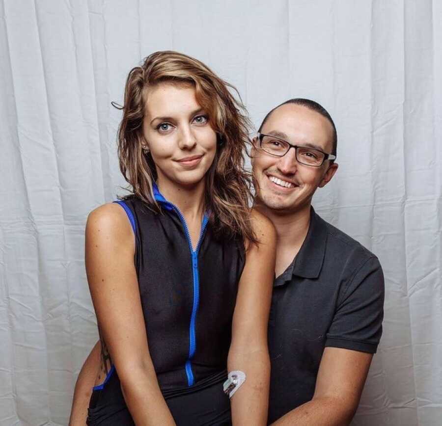 Young woman sits on her boyfriend's lap for a photo together