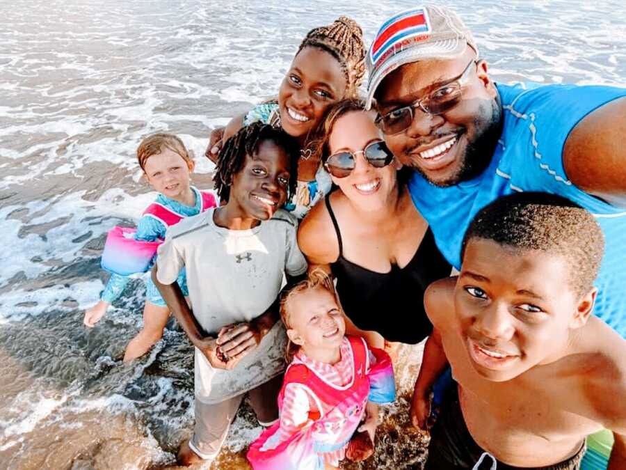 Blended family take a selfie together during a family day at the beach