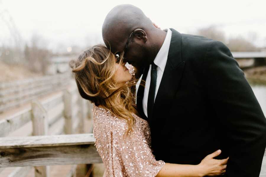 Newly-engaged couple share intimate moment while taking engagement photos together