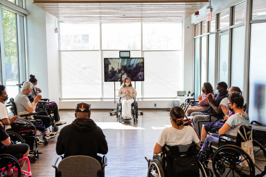 Paralyzed yoga instructor leads a chair yoga class