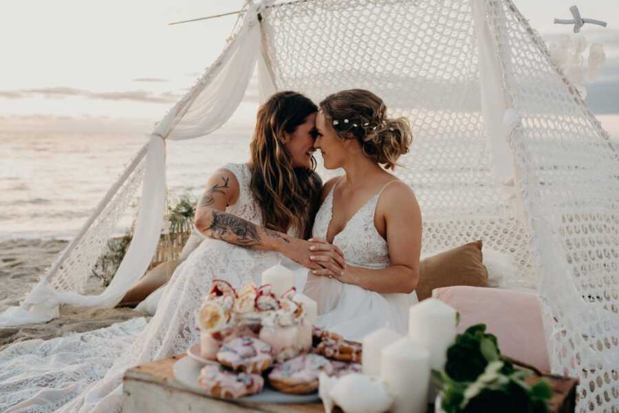 Wedding photography of Lesbian couple wearing white dresses and at the beach 