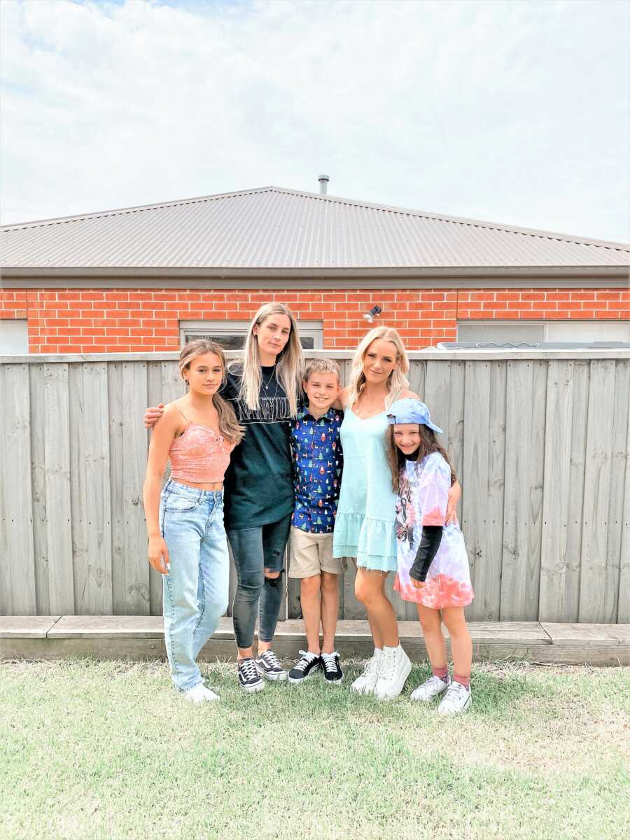 Mom standing next to her 3 kids and her girlfriend 