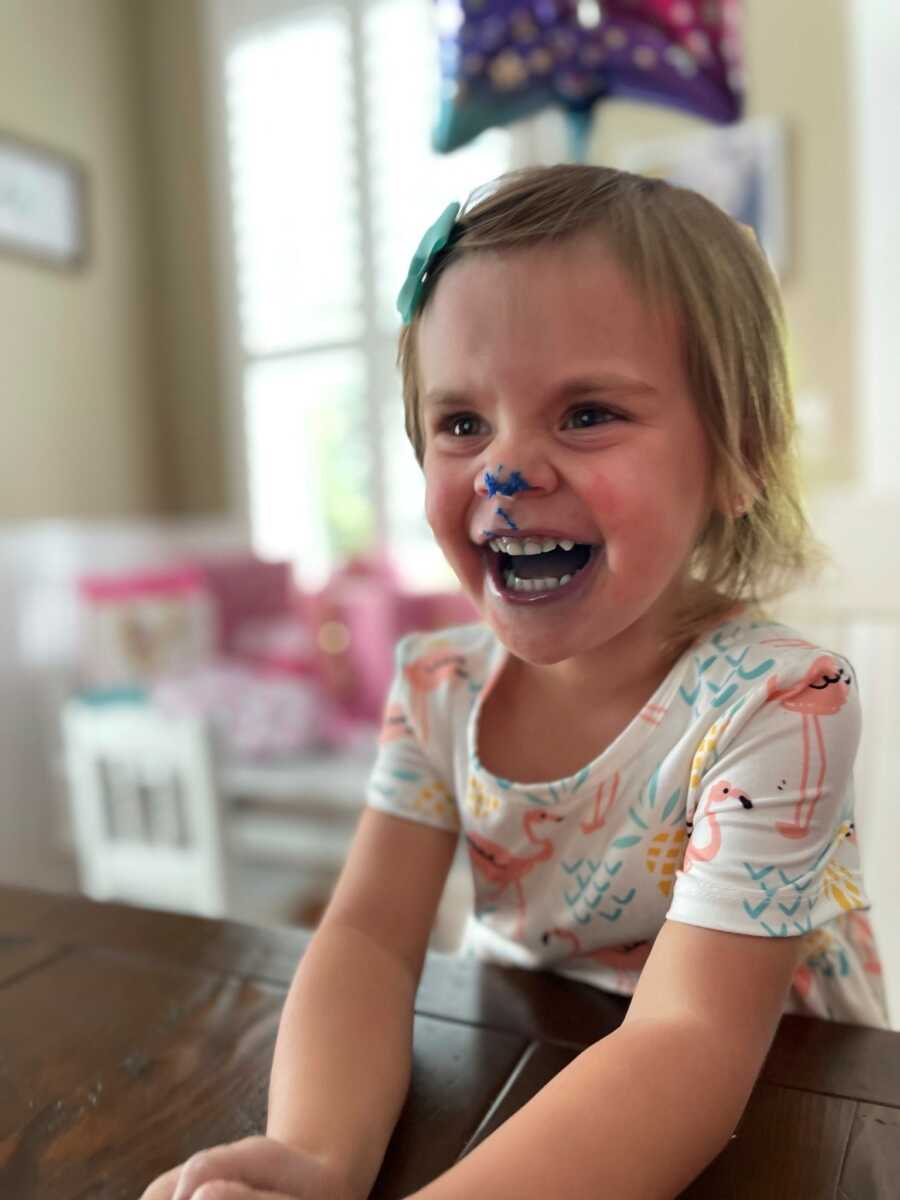 little girl with frosting on her nose