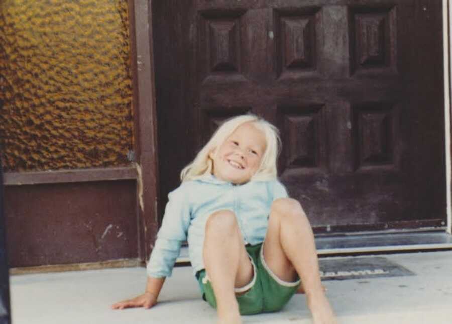 little girl in front of a door