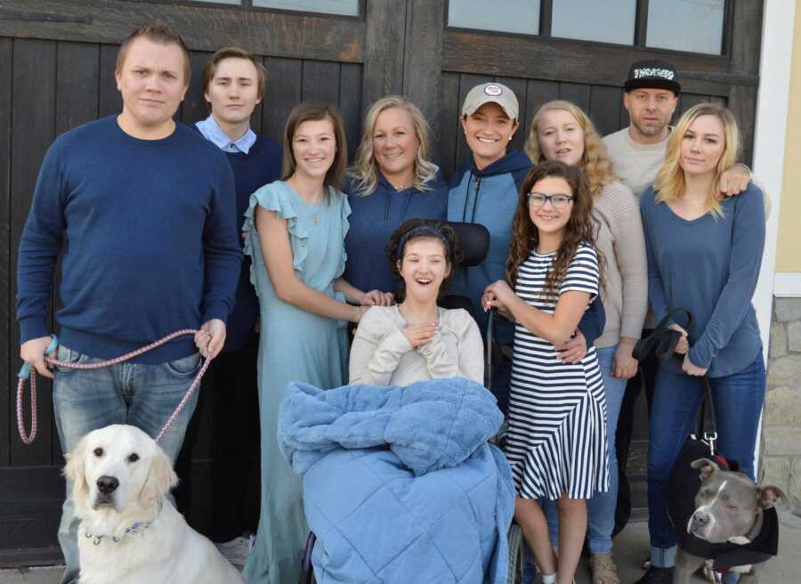 Blended family take photo together wearing various shades of blue and white