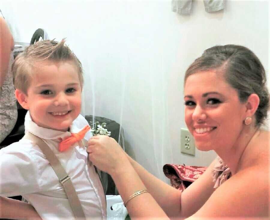 Mom fixing her young son's suit before a wedding 