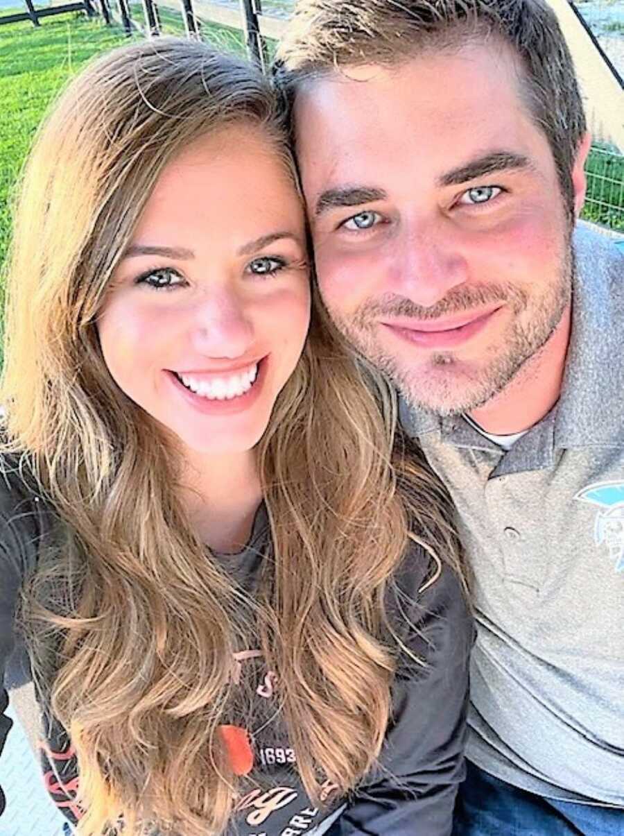 Couple take photo together while smiling with their foreheads against each other's