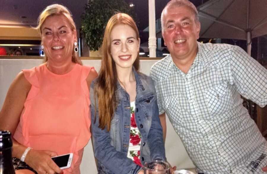 Parents take a photo with their daughter while enjoying a dinner out together