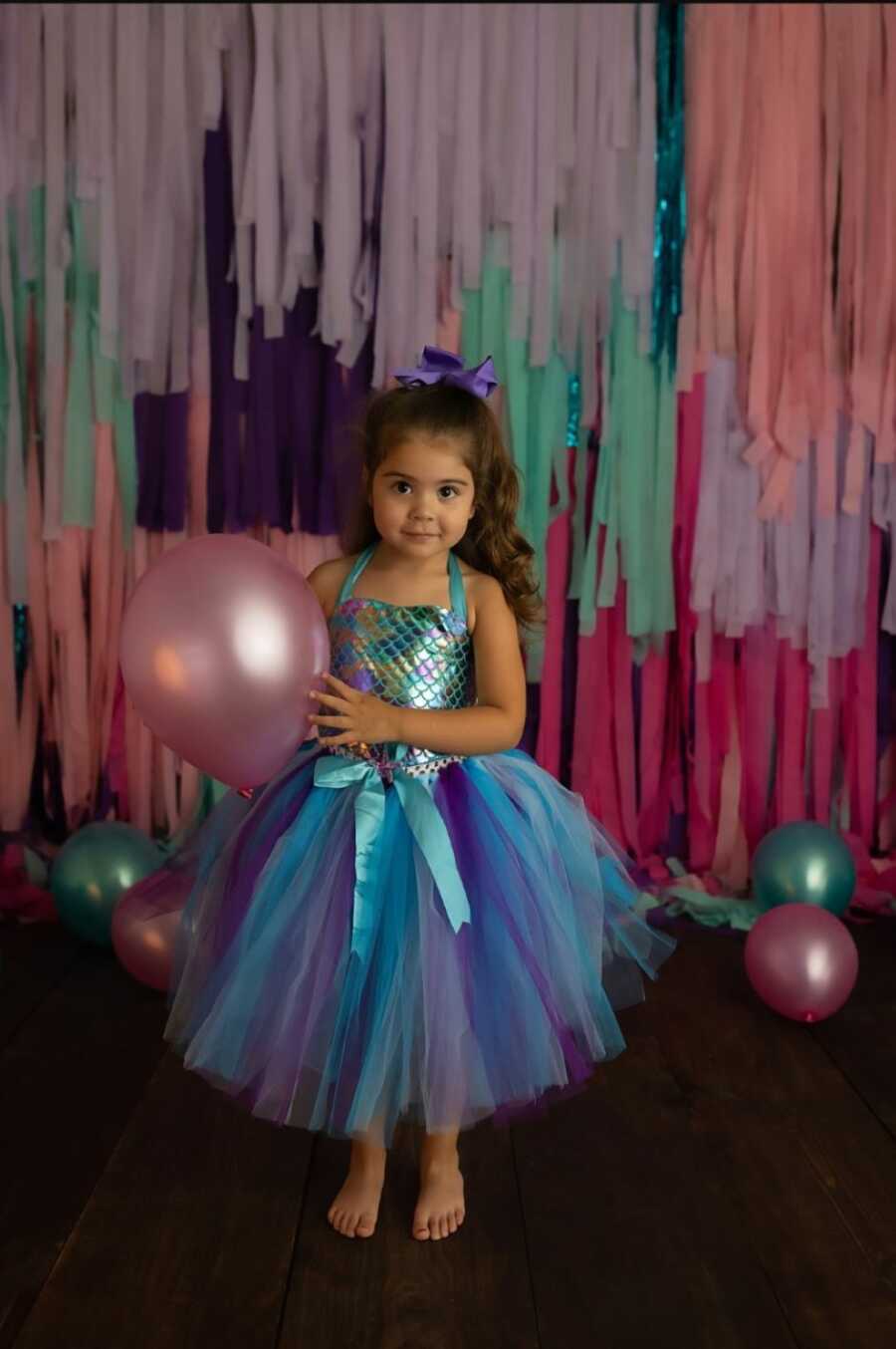 Young girl wears mermaid-inspired dress during a photoshoot